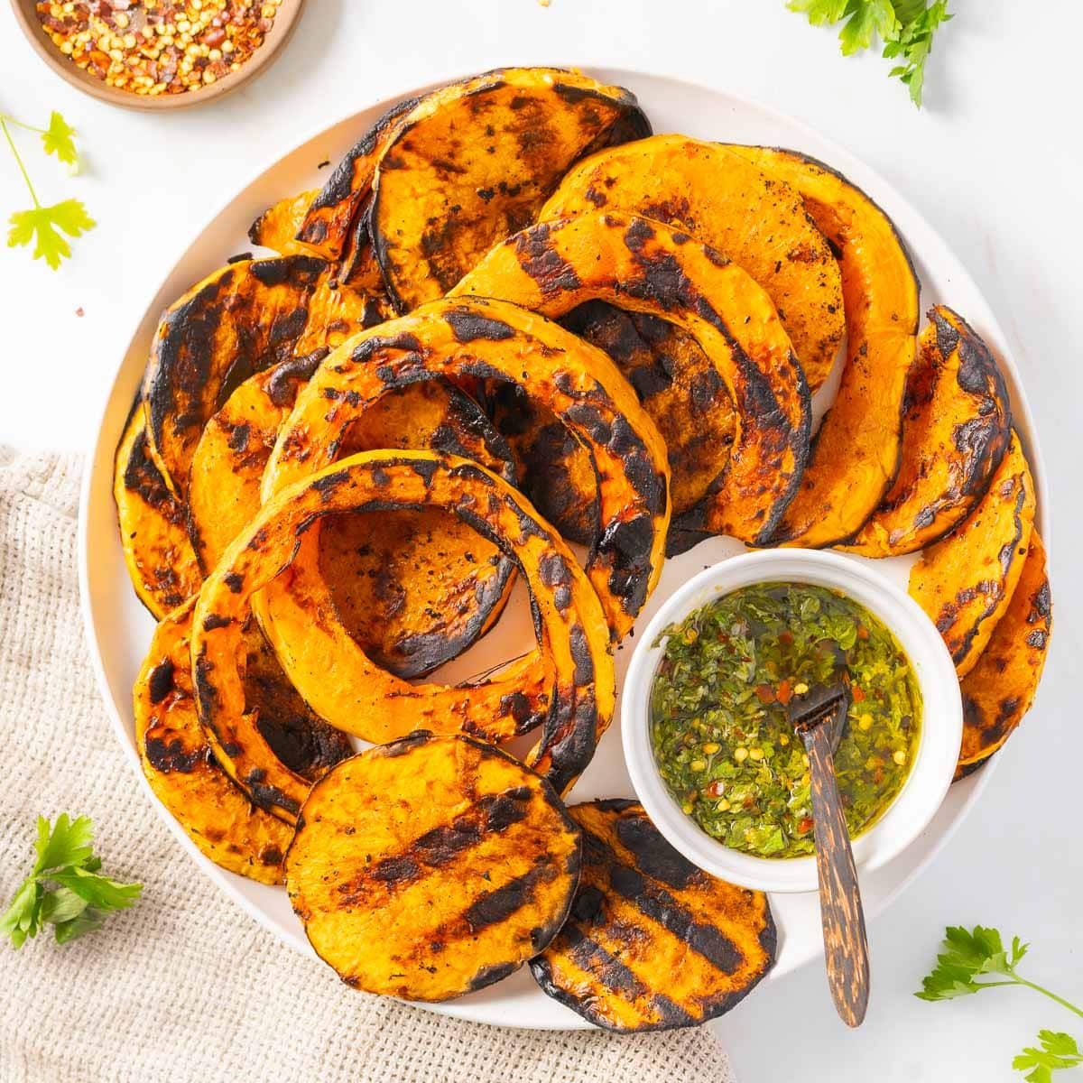 Grilled butternut squash slices on a plate.